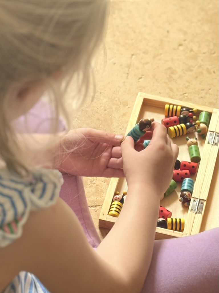 A child playing with wooden toys indoors at the farmhouse
